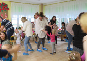 Dzieci tańczą wspólnie z rodzicami.